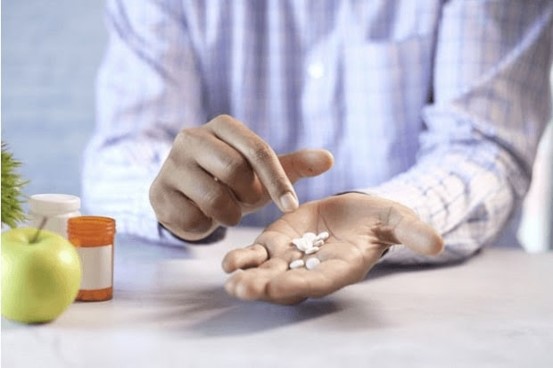 Man holding white tablets that represent the aciclovir dosage